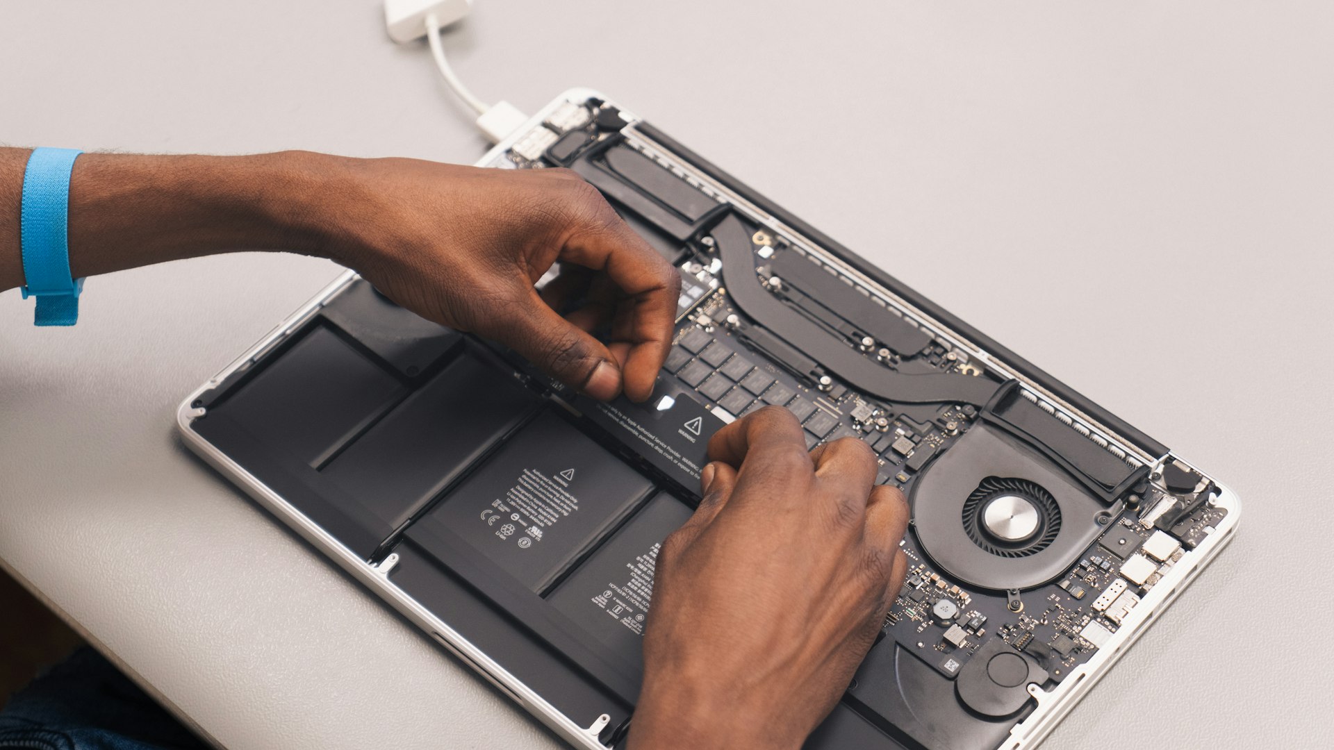 Technician repairing a laptop motherboard at Universal Phone Services Woden, using professional tools and genuine parts for reliable performance.